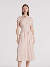 a lady in a light pink silk maxi dress